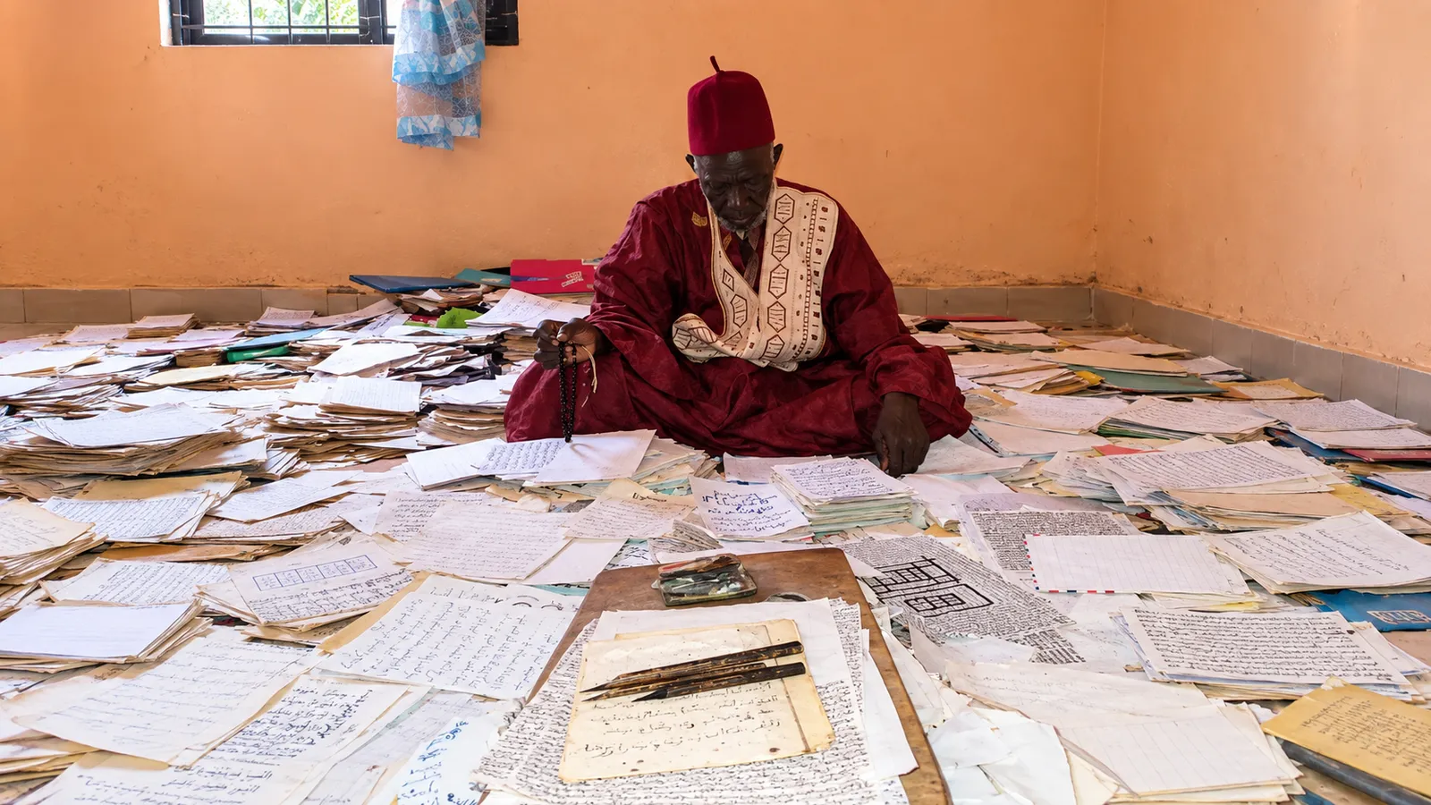 Marabout Sory entouré de manuscrits et de cahiers d’étude